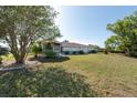 Expansive backyard featuring a screened lanai, mature trees and lush green lawn at 103 El Turco Ct, Sun City Center, FL 33573