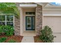 Close up of front door with sidelight and stone facade at 10734 Breaking Rocks Dr, Tampa, FL 33647