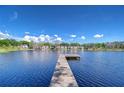 Scenic view of the lake and waterfront homes from the end of the wooden dock on a sunny day at 13329 N Armenia Ave, Tampa, FL 33613