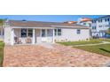 Charming home featuring a brick driveway, covered entry, and manicured lawn at 145 174Th Terrace E Dr, Redington Shores, FL 33708