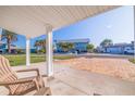 Relaxing covered patio view overlooking the neighborhood street and lush landscaping at 145 174Th Terrace E Dr, Redington Shores, FL 33708