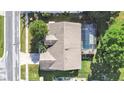 Aerial view of home shows the well-maintained roof, lush landscaping, and inviting screened-in pool area at 1472 Overland Dr, Spring Hill, FL 34608