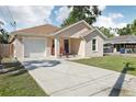 Single-story home featuring a driveway, garage, front porch, and well-manicured lawn at 1614 E Nome St, Tampa, FL 33604