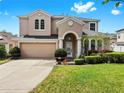 Beautiful two-story home showcasing manicured landscaping, an arched entryway, and a two-car garage at 312 Taxter Run Ln, Valrico, FL 33594