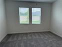 Bright bedroom with neutral carpet, two windows, and blinds at 31753 Griffin Sands Ln, San Antonio, FL 33576