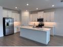 Modern kitchen with white cabinets, stainless steel appliances, and a central island at 31753 Griffin Sands Ln, San Antonio, FL 33576