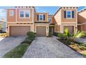 Inviting townhouse exterior with brick driveway, a one car garage, and well-manicured landscaping at 3214 Painted Blossom Ct, Lutz, FL 33558