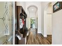 Inviting home entryway featuring wood-look tile flooring, arched doorways and a convenient mudroom bench at 3822 Balcony Breeze Dr, Land O Lakes, FL 34638