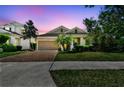 Beautiful single-Gathering home with brick driveway, manicured lawn, and stunning twilight sky backdrop at 3822 Balcony Breeze Dr, Land O Lakes, FL 34638