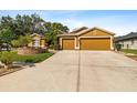 Beautiful home showcasing a well-manicured lawn and a spacious driveway leading to a two-car garage at 4508 Compass Oaks Dr, Valrico, FL 33596