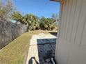 Spacious backyard with mature trees, a block fence and a concrete patio at 4911 Largo Ter, New Port Richey, FL 34652