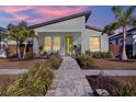 Modern home with a gray exterior, complemented by lush landscaping, palm trees and a vibrant yellow front door at 511 45Th N Ave, St Petersburg, FL 33703