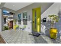 Inviting front porch with patterned tile, contemporary seating, and a bright yellow door at 511 45Th N Ave, St Petersburg, FL 33703