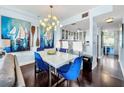 Elegant dining room with modern lighting, a white table, and ocean-themed artwork at 525 Bahia Beach Blvd, Ruskin, FL 33570