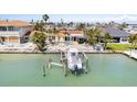 Aerial view of waterfront home, pool, boat dock, and lush landscaping on a sunny day at 571 Johns Pass Ave, Madeira Beach, FL 33708