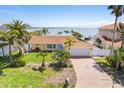 Charming home with a well-manicured lawn, palm trees, and a convenient two-car garage at 571 Johns Pass Ave, Madeira Beach, FL 33708