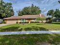 Well-manicured front lawn and a long driveway leading to the attached two-car garage at 5905 Caroline Dr, Wesley Chapel, FL 33545