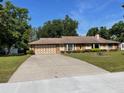 Spacious driveway leads to a home with a well-maintained lawn and mature landscaping at 5905 Caroline Dr, Wesley Chapel, FL 33545