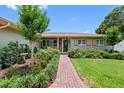 Attractive front entrance with brick pathway, decorative shrubs, and a cozy porch seating area at 8300 37Th N Ave, St Petersburg, FL 33710
