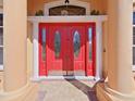 Close-up of a stylish red front door with decorative glass panels and sidelights at 9460 Bearfoot Trl, Weeki Wachee, FL 34613