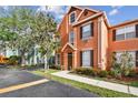 Inviting townhouse with a manicured front lawn, mature trees, and a well-maintained exterior at 9740 Lake Chase Island Way # 9740, Tampa, FL 33626