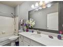 Well-lit bathroom with a large framed mirror, shower-tub combo, white vanity, and quartz countertop at 10442 Villa View Cir, Tampa, FL 33647