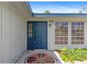 Charming entrance with a blue door, mosaic, and well-lit exterior, creating a welcoming appeal at 116 Solana St, North Port, FL 34287