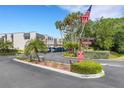 Welcoming Fernwood community entrance featuring lush landscaping and the American flag at 117 Fernwood Cir # 117, Seminole, FL 33777
