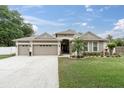 Charming single-story home with a three-car garage, well-manicured lawn, and inviting curb appeal at 12304 Freesia Ct, Riverview, FL 33569