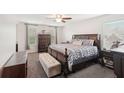 Spacious main bedroom with a large bed, dresser, neutral tones, and ample natural light from the window at 12402 Fairlawn Dr, Riverview, FL 33579