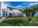 Inviting two-story townhome with manicured lawn and mature palm trees enhances curb appeal in a serene neighborhood at 1451 Gulf Blvd # 207, Clearwater Beach, FL 33767
