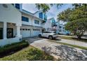 Charming townhome featuring white siding, attached garage, and carefully designed landscaping at 14692 Seminole Trl, Seminole, FL 33776