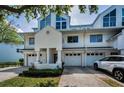 Charming townhome featuring white siding, attached garage, and manicured landscaping at 14692 Seminole Trl, Seminole, FL 33776