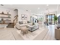 Bright living room with white floors, modern furnishings, and an open floor plan leading into the kitchen at 18860 Beautyberry Ct, Lutz, FL 33558