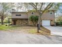 Charming home with stone accents, an attached garage, mature trees, and a well-maintained lawn at 18914 5Th St, Lutz, FL 33548