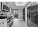 Bright kitchen with stainless steel appliances, white cabinets and white countertops and stacked washer and dryer at 19111 Vista Bay Dr # 304, Indian Shores, FL 33785