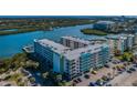 Exterior of condo with parking lot and lush tropical landscaping, with marina and water views at 19531 Gulf Blvd # 205, Indian Shores, FL 33785