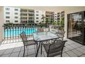 View of a patio area that overlooks the community pool, with a table and chairs for outdoor relaxation at 19531 Gulf Blvd # 205, Indian Shores, FL 33785