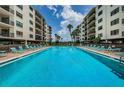 Resort-style pool with lounge chairs, located between two buildings, surrounded by lush tropical landscaping at 19531 Gulf Blvd # 205, Indian Shores, FL 33785