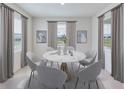 Bright dining room featuring a round marble table, six chairs, and large windows with views of the outdoors at 19657 Gladeview Way, Land O Lakes, FL 34638
