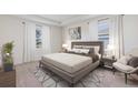 Comfortable main bedroom with tray ceiling, neutral color palette, large windows, and stylish furniture at 19657 Gladeview Way, Land O Lakes, FL 34638
