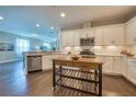 Bright eat-in kitchen featuring modern cabinetry, stainless appliances, and a portable island at 2024 Sidney St, Clearwater, FL 33763