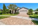 Inviting home featuring a brick paver driveway, well-maintained landscaping, and a manicured lawn at 21627 Pearl Crescent Ct, Land O Lakes, FL 34637