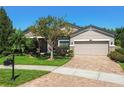 Beautiful home with manicured landscaping, brick paver driveway, and a well-maintained lawn at 21627 Pearl Crescent Ct, Land O Lakes, FL 34637