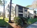 Charming condo units with lush landscaping, mature trees, and exterior architectural details at 337 Woodlake Wynde, Oldsmar, FL 34677