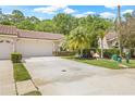 Inviting single-story home with a well-maintained lawn, a two-car garage, and a charming barrel tile roof at 3810 Darston St, Palm Harbor, FL 34685
