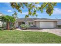 Charming single-story home with well-manicured lawn, mature trees, and a welcoming entrance at 3901 E Eden Roc Cir, Tampa, FL 33634