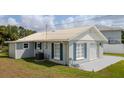 Charming home featuring a well-maintained lawn, white roof, and blue shutters enhancing its curb appeal at 4508 26Th S Ave, Tampa, FL 33619