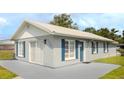 View of the exterior of the home, painted in neutral tones with contrasting blue shutters at 4508 26Th S Ave, Tampa, FL 33619