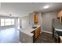 Modern kitchen with wood cabinets, stainless appliances, and stone countertops at 5000 Culbreath Key Way # 9-104, Tampa, FL 33611